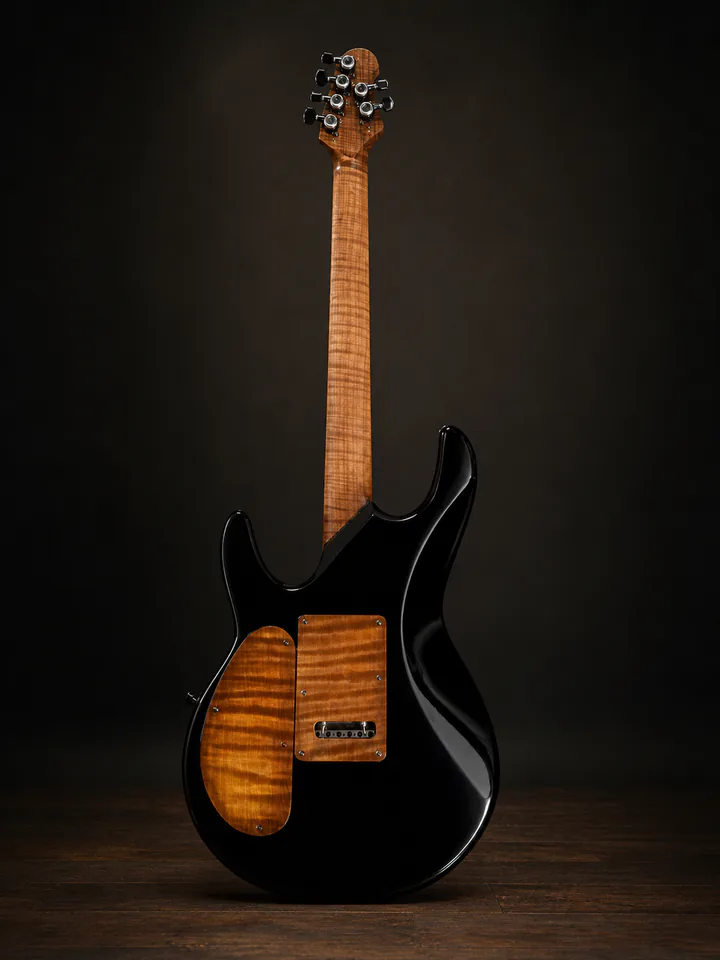 Black custom guitar back with figured maple neck on a professional studio background