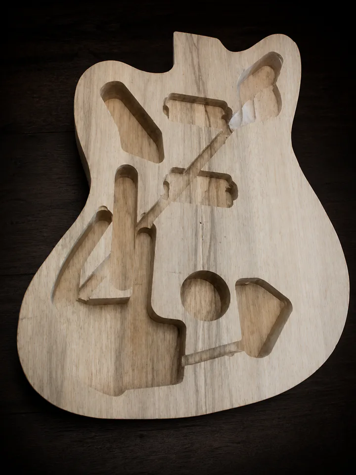 Interior routing in a carved semi-hollow guitar body on a professional studio background