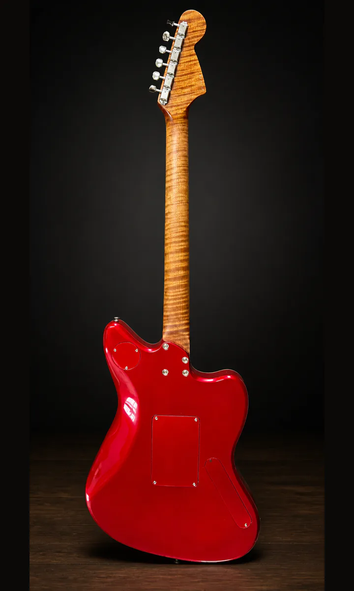 Back of red semi-hollow guitar with figured maple neck on a studio background