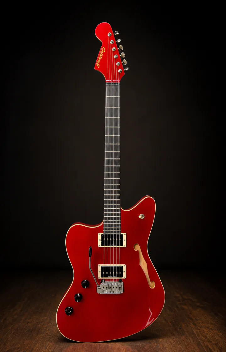 Red semi-hollow Caldwell custom guitar on a professional studio background