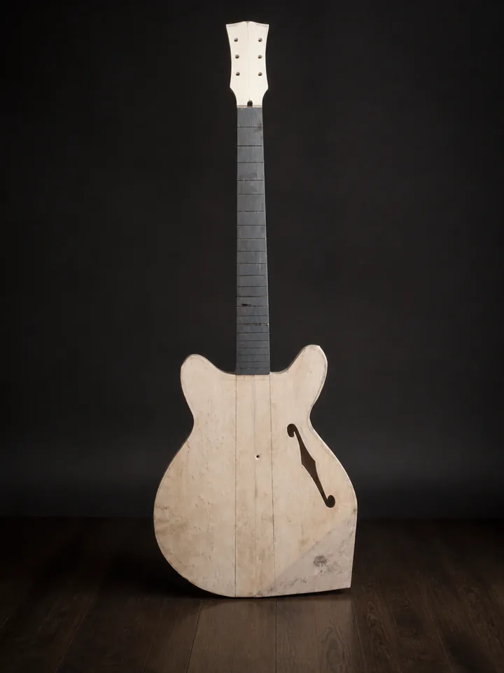 Unfinished semi-hollow guitar body and neck during fitting on a professional studio background